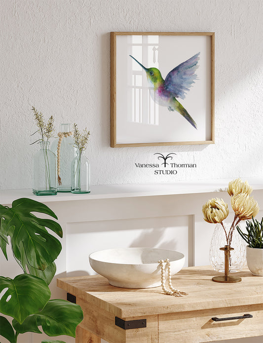 Framed Hummingbird in flight watercolor art print by Vanessa Thorman hanging in a home