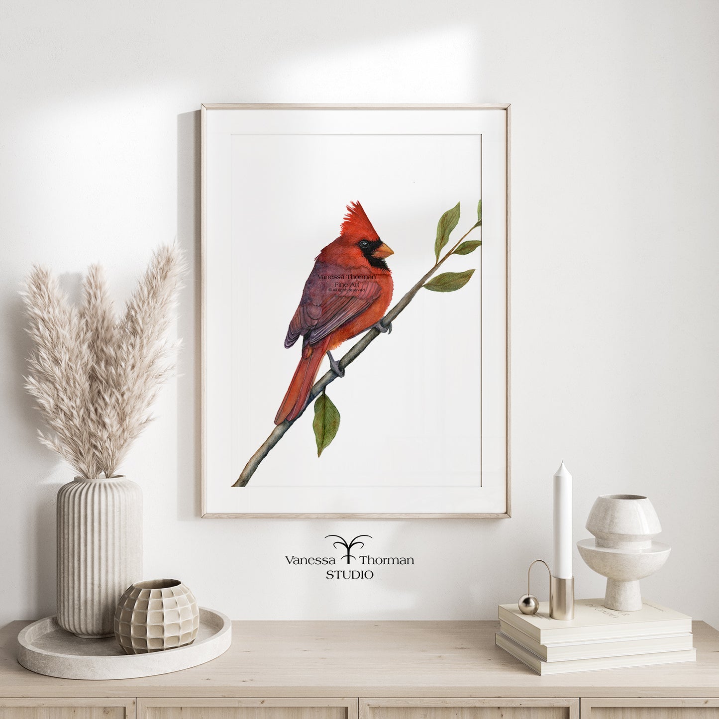 Framed Northern Cardinal watercolor art print by Vanessa Thorman hanging over a console table