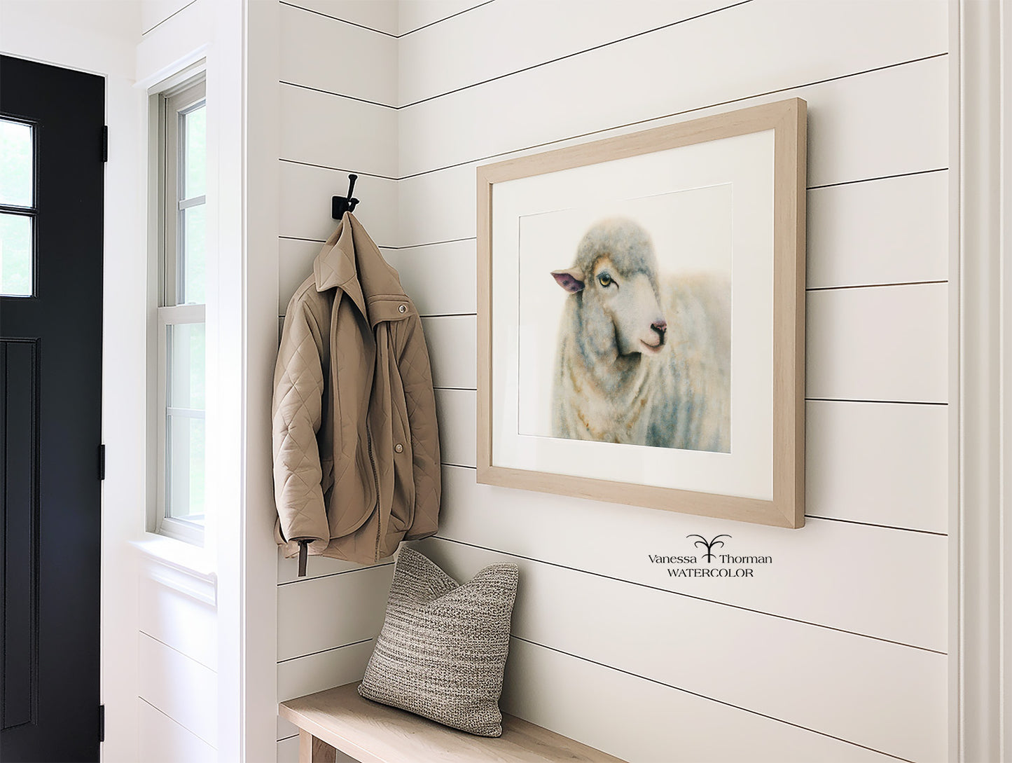 Framed "Duchess" sheep watercolor art print hanging in an entryway