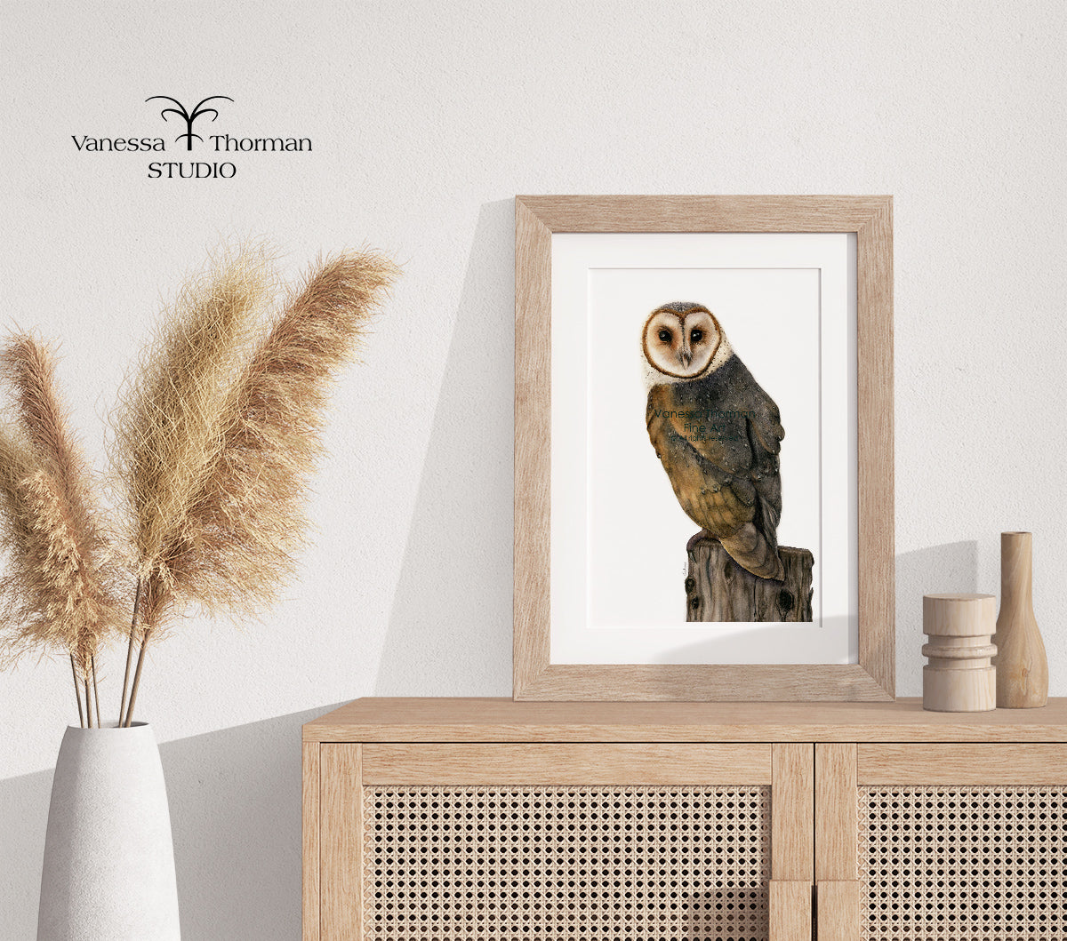 Framed Barn Owl watercolor art print by Vanessa Thorman on a console table.