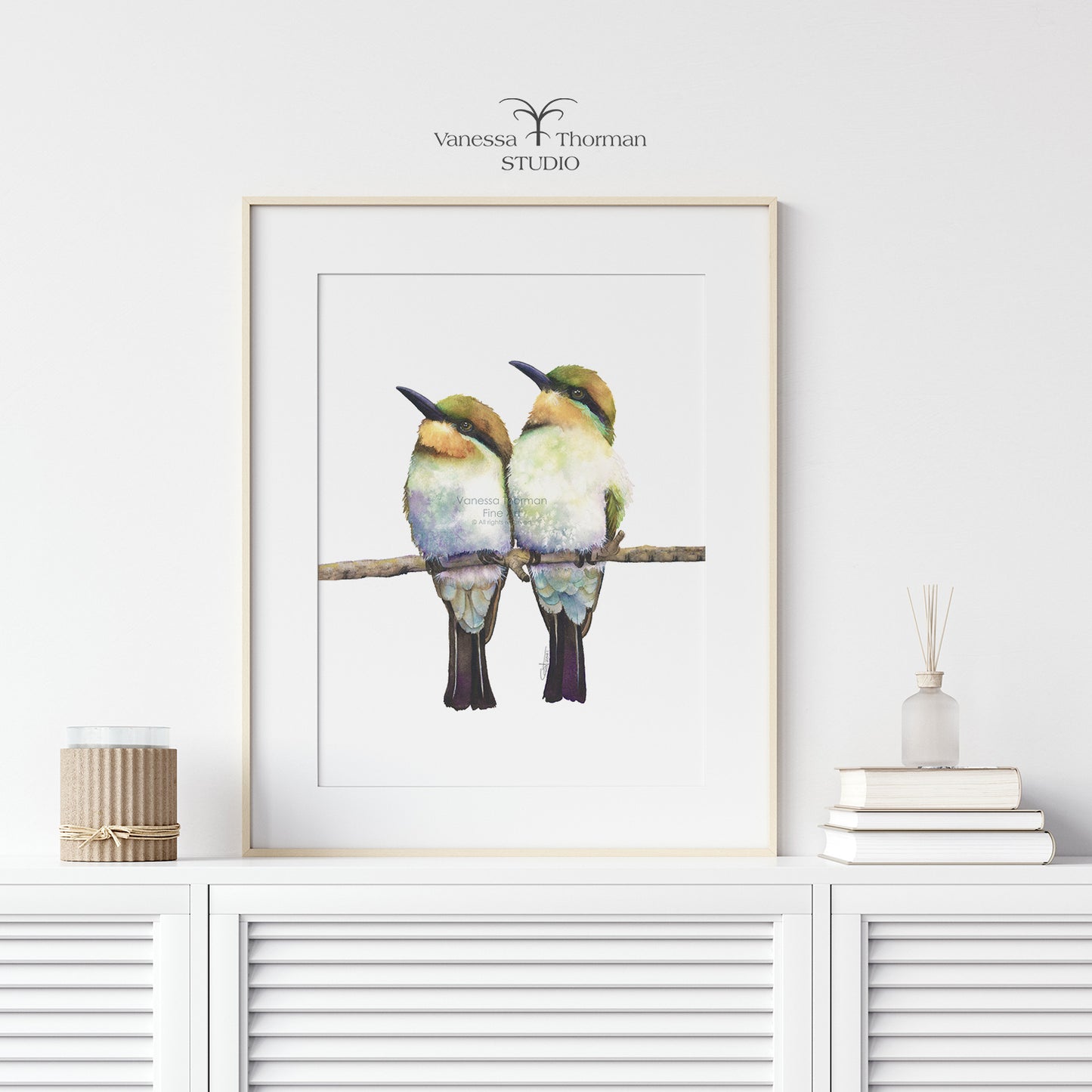 Framed "Birds of a Feather" Bee-Eater watercolor art print by Vanessa Thorman on a console table