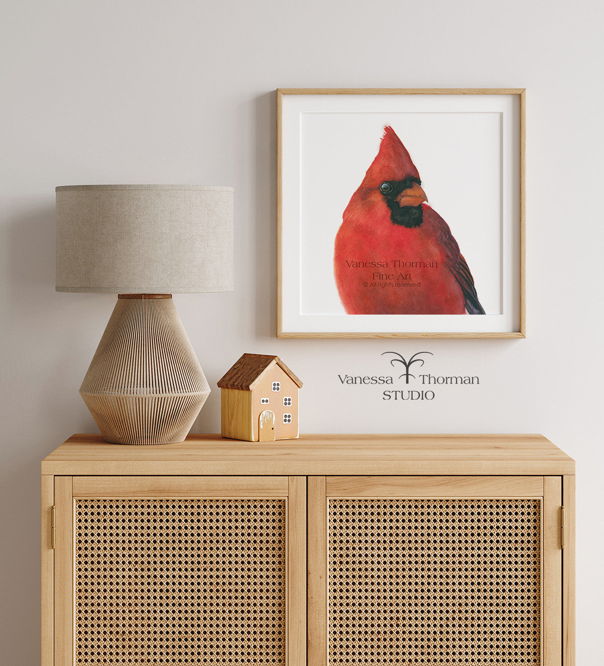 Framed "Charles," a close-up Northern Cardinal watercolor art print by Vanessa Thorman above a console table