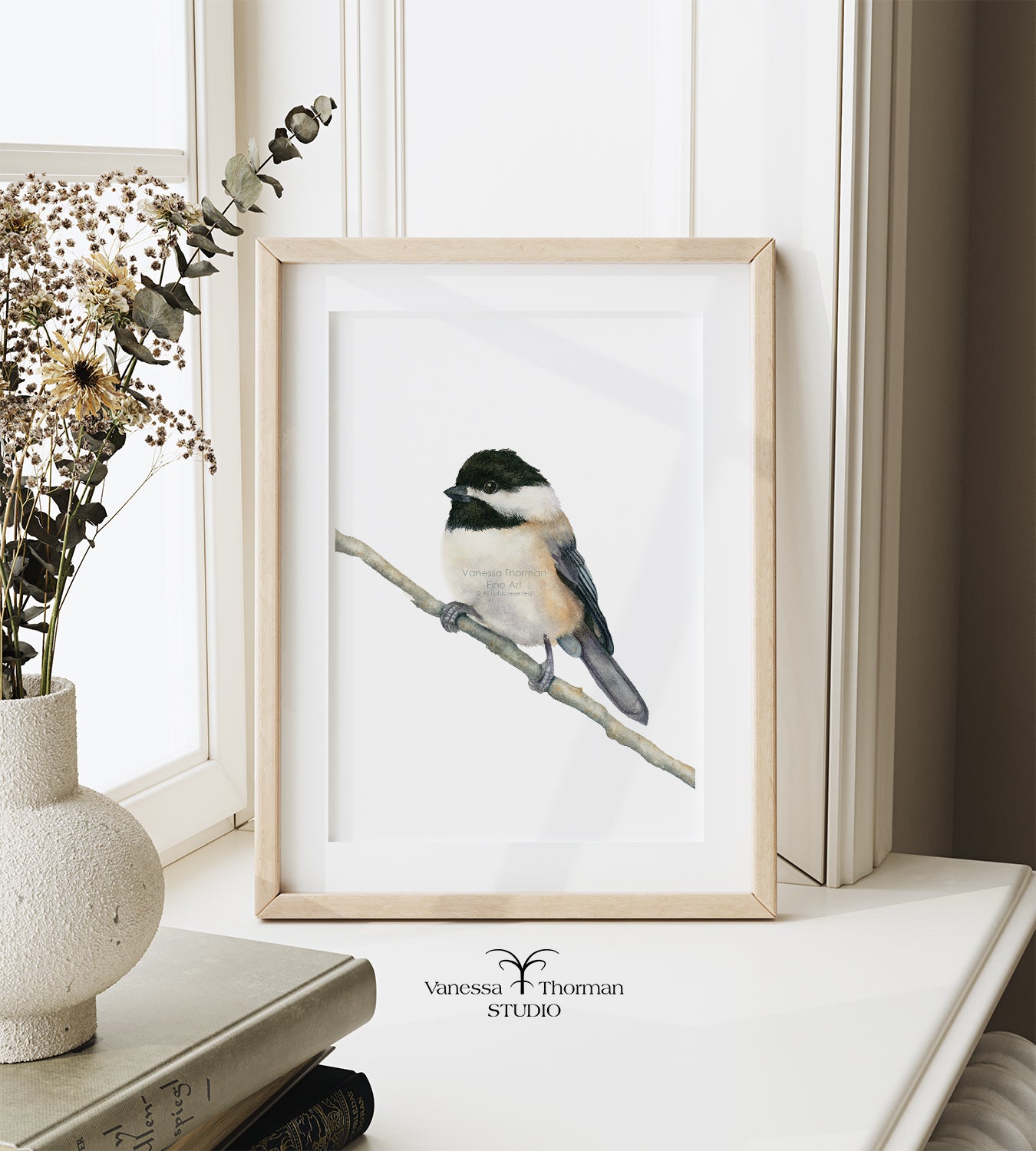 Framed Chickadee watercolor art print by Vanessa Thorman on a windowsill