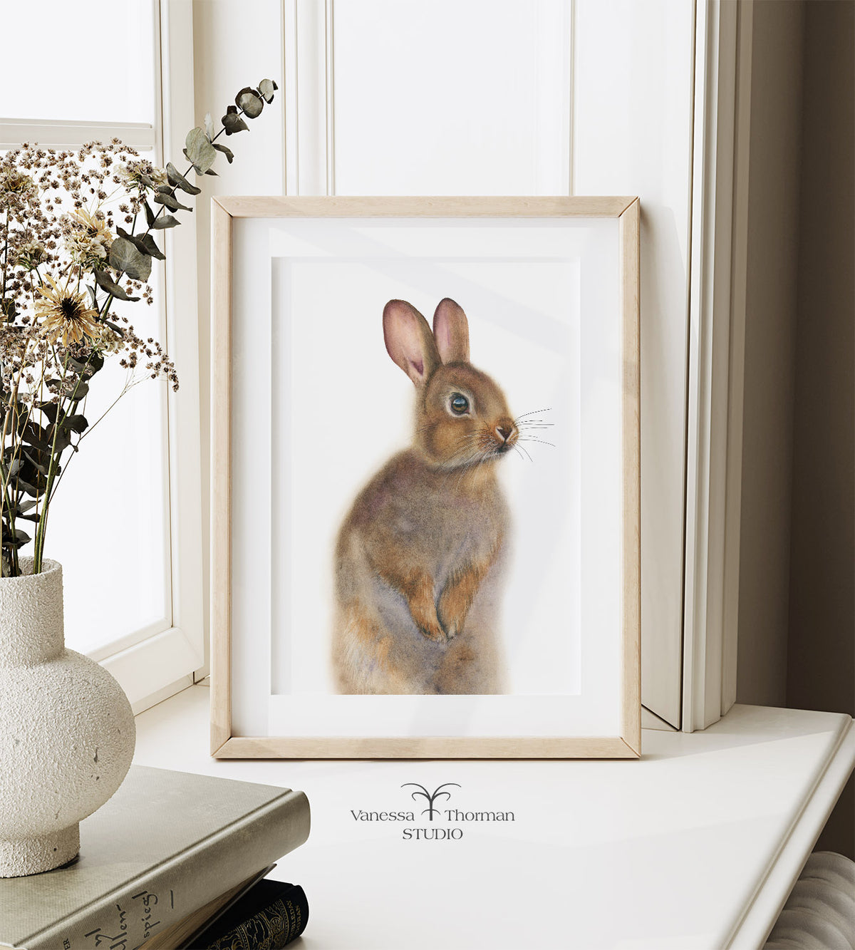 Framed "Nutmeg the Bunny" watercolor art print by Vanessa Thorman sitting on a windowsill
