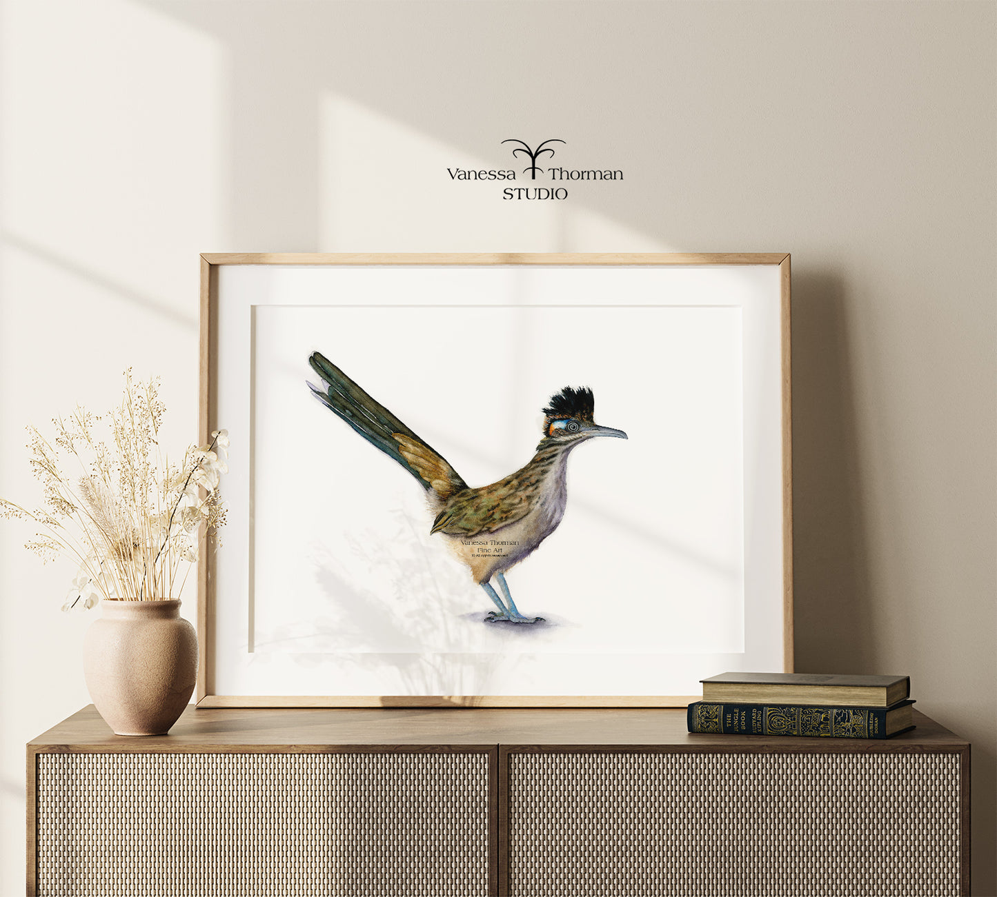 Framed Roadrunner watercolor art print with a white background on a console table