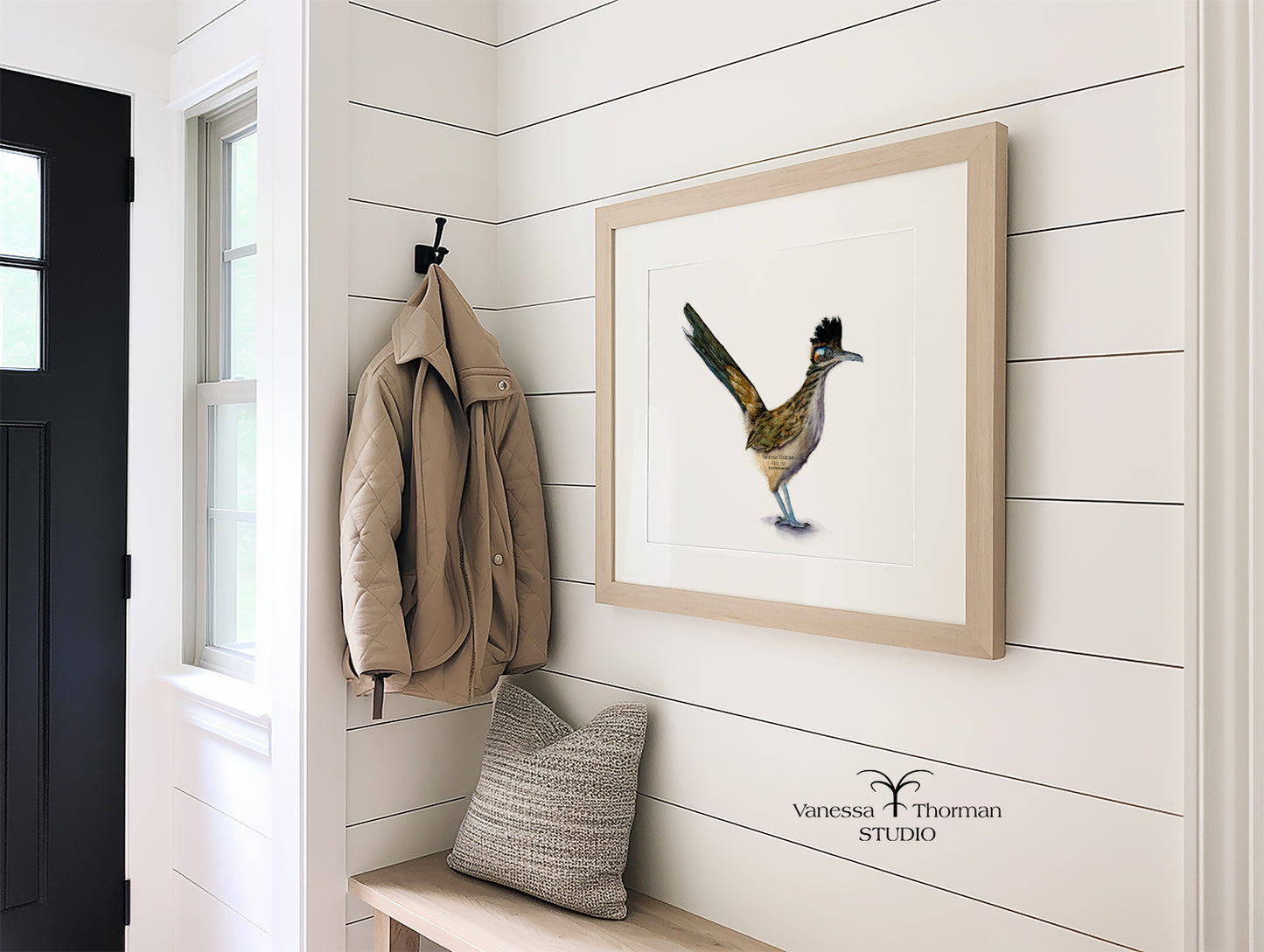 Framed Roadrunner watercolor art print with a white background in an entry way