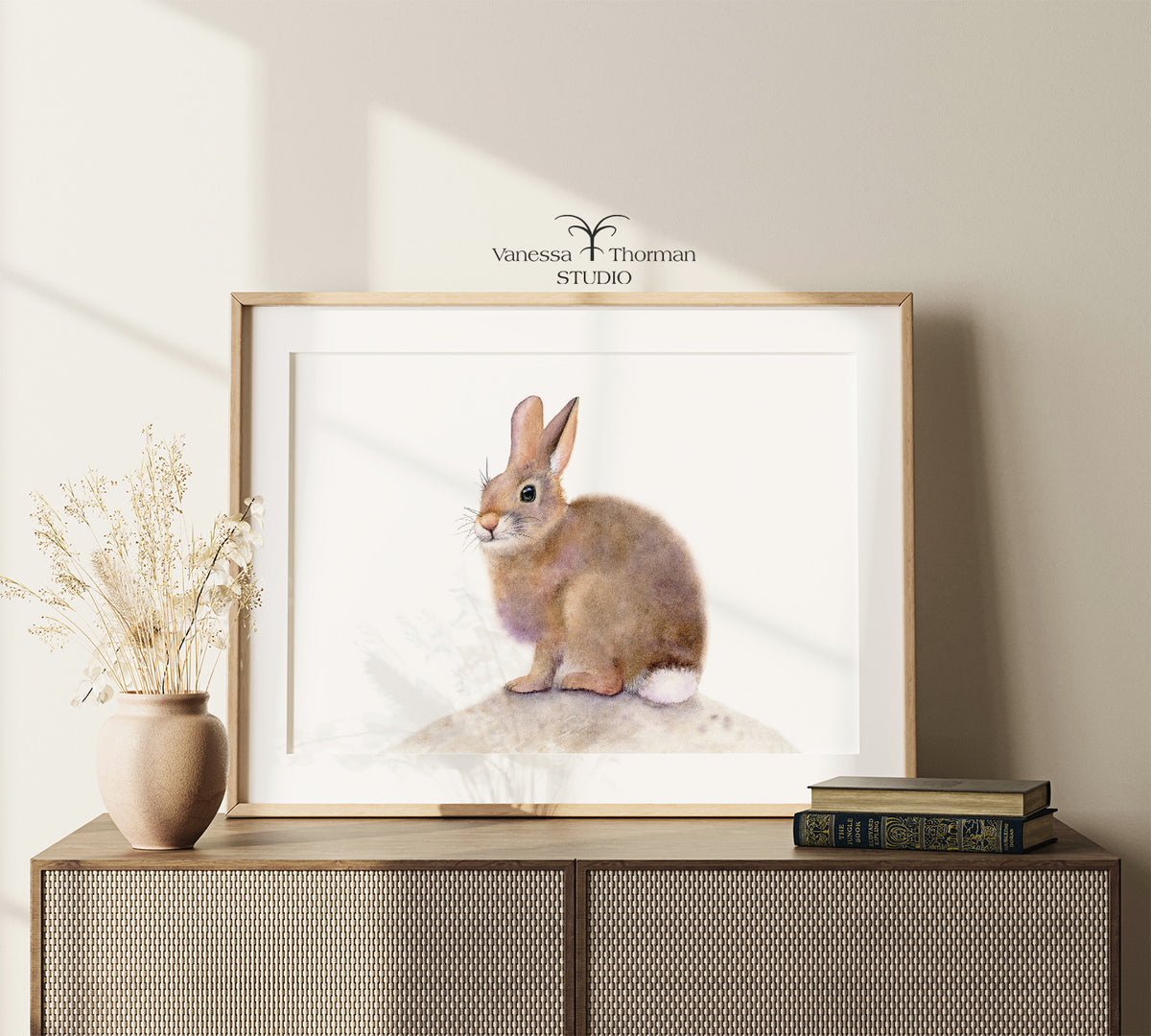 Framed "Some Bunny to Love" bunny watercolor art print by Vanessa Thorman on a console table