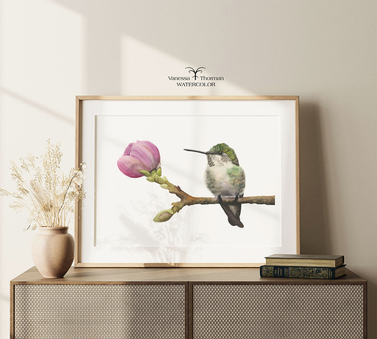 Framed "Hummingbird in Bloom" watercolor art print displayed on a console table
