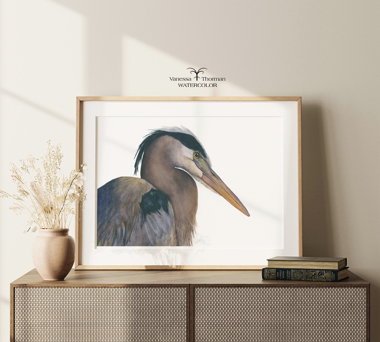 Framed "August" Great Blue Heron watercolor art print by Vanessa Thormna displayed on a console table