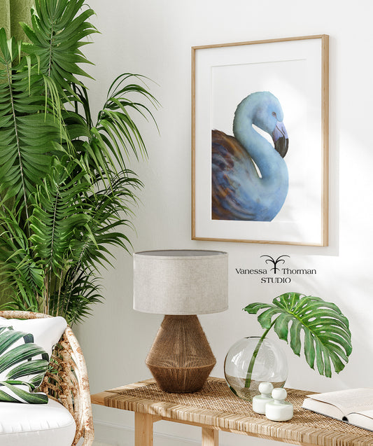 Framed Blue Flamingo watercolor art print by Vanessa Thorman displayed in a room with a palm plant