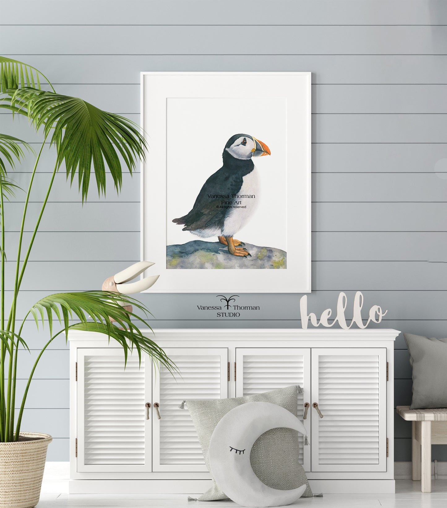 Framed puffin watercolor art print on a plain background hanging in a room