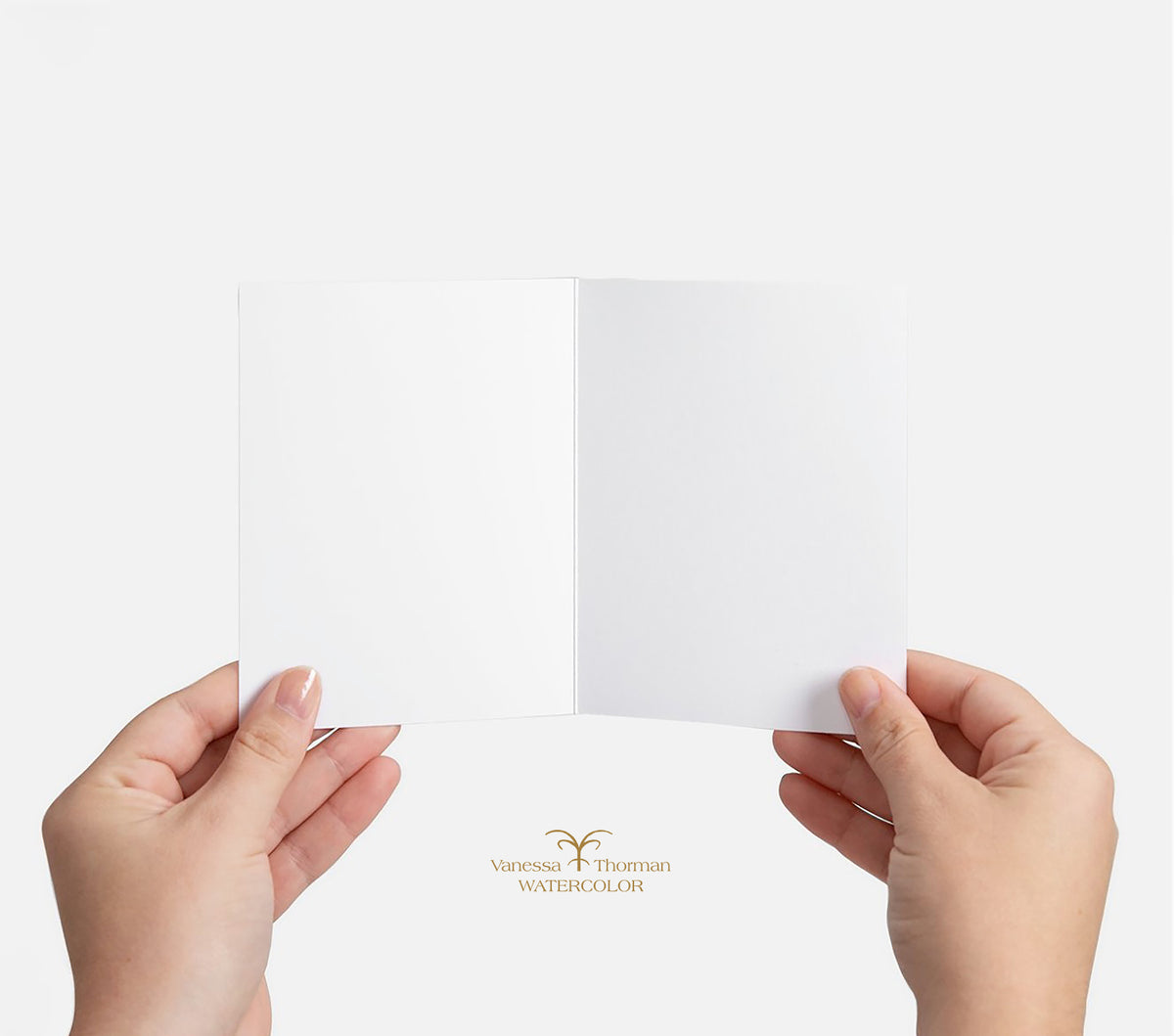 Hands holding a blank watercolor notecard, showing the unlined interior