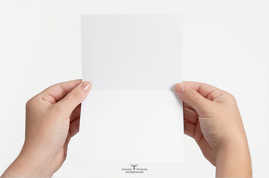 Hands holding a blank watercolor notecard, showing the unlined interior